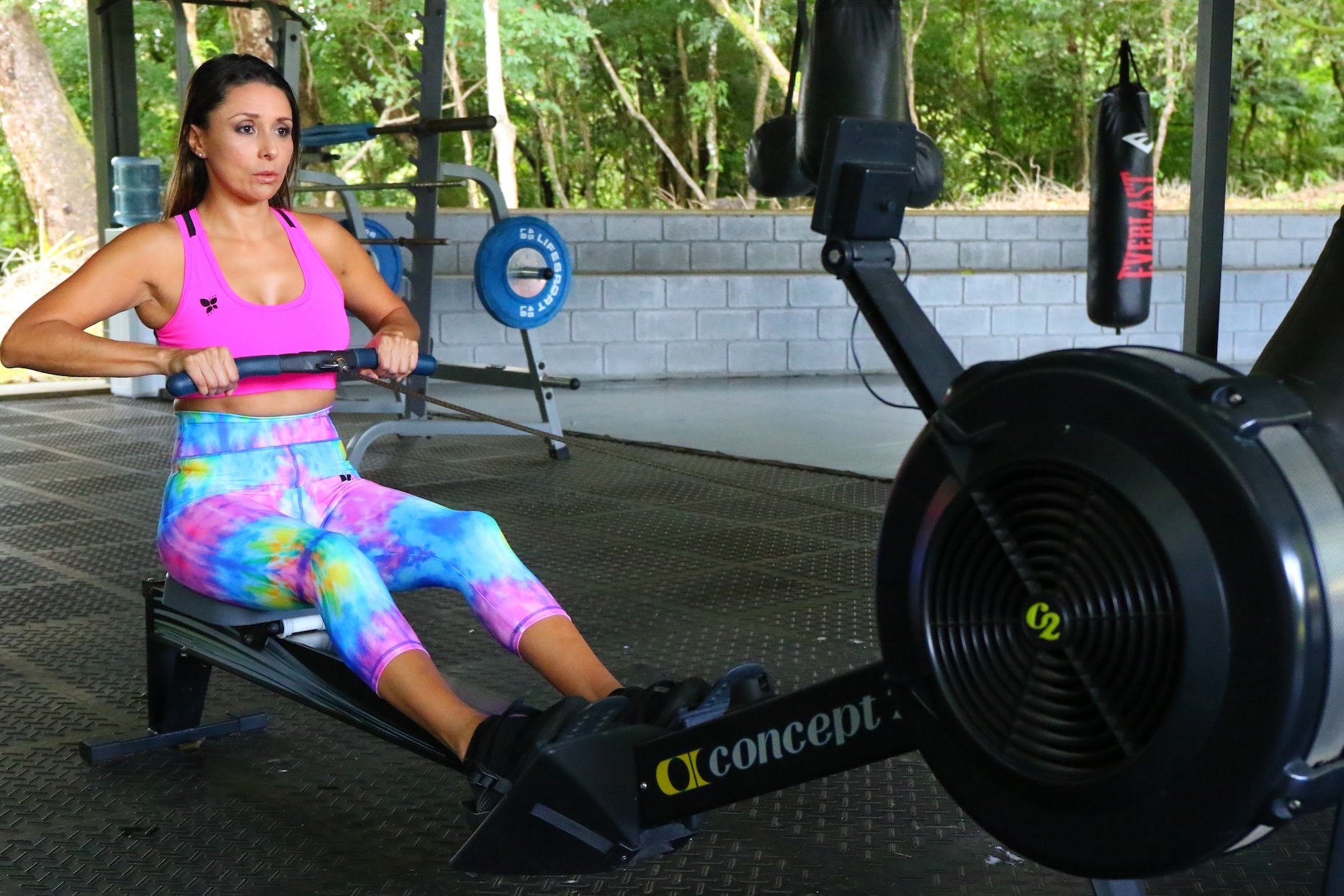 woman in pink tank top and pink pants sitting on black stationary bike